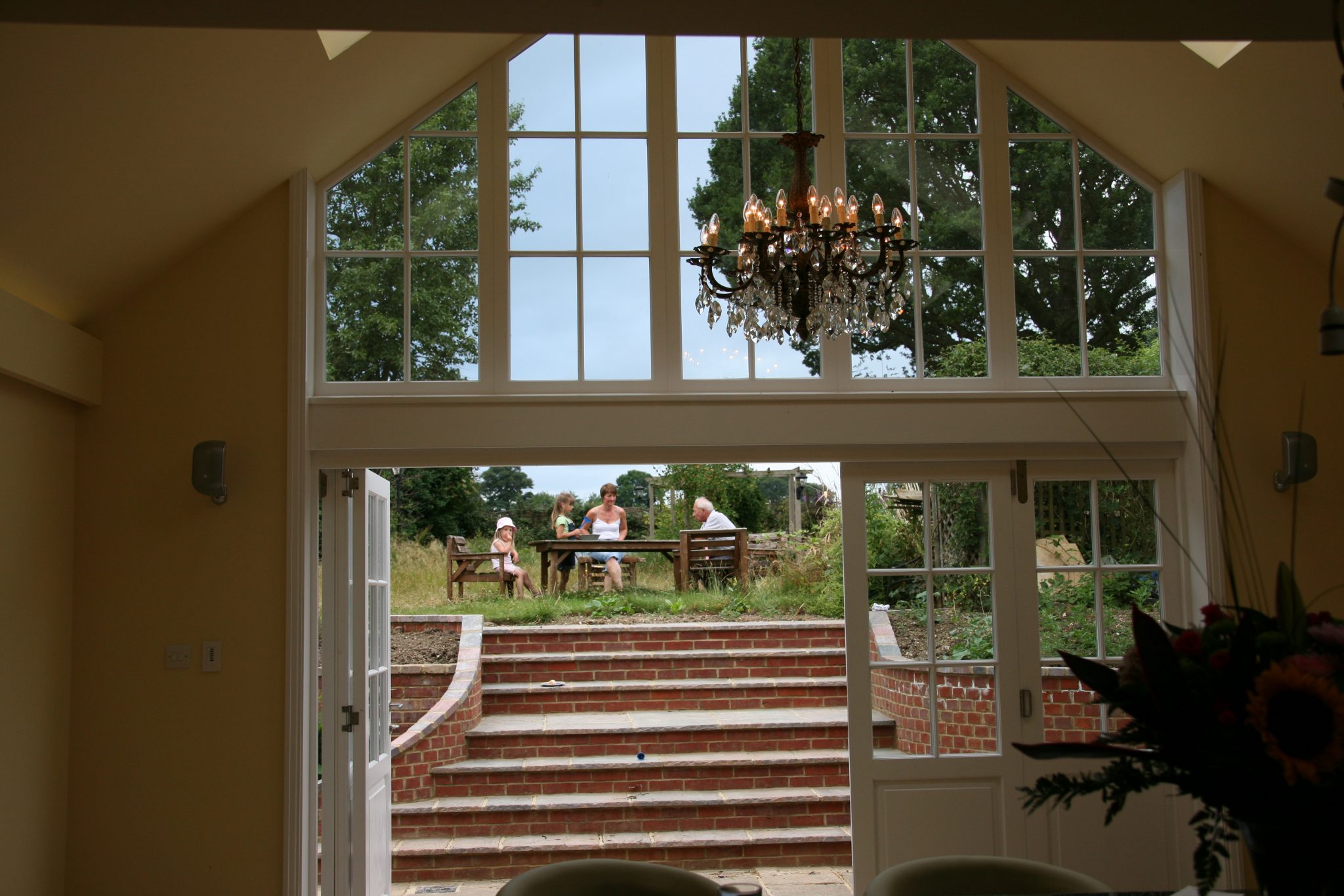 Bifold back doors showing stairs, garden and family eating